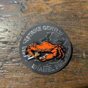 Crab enamel pin on wooden table