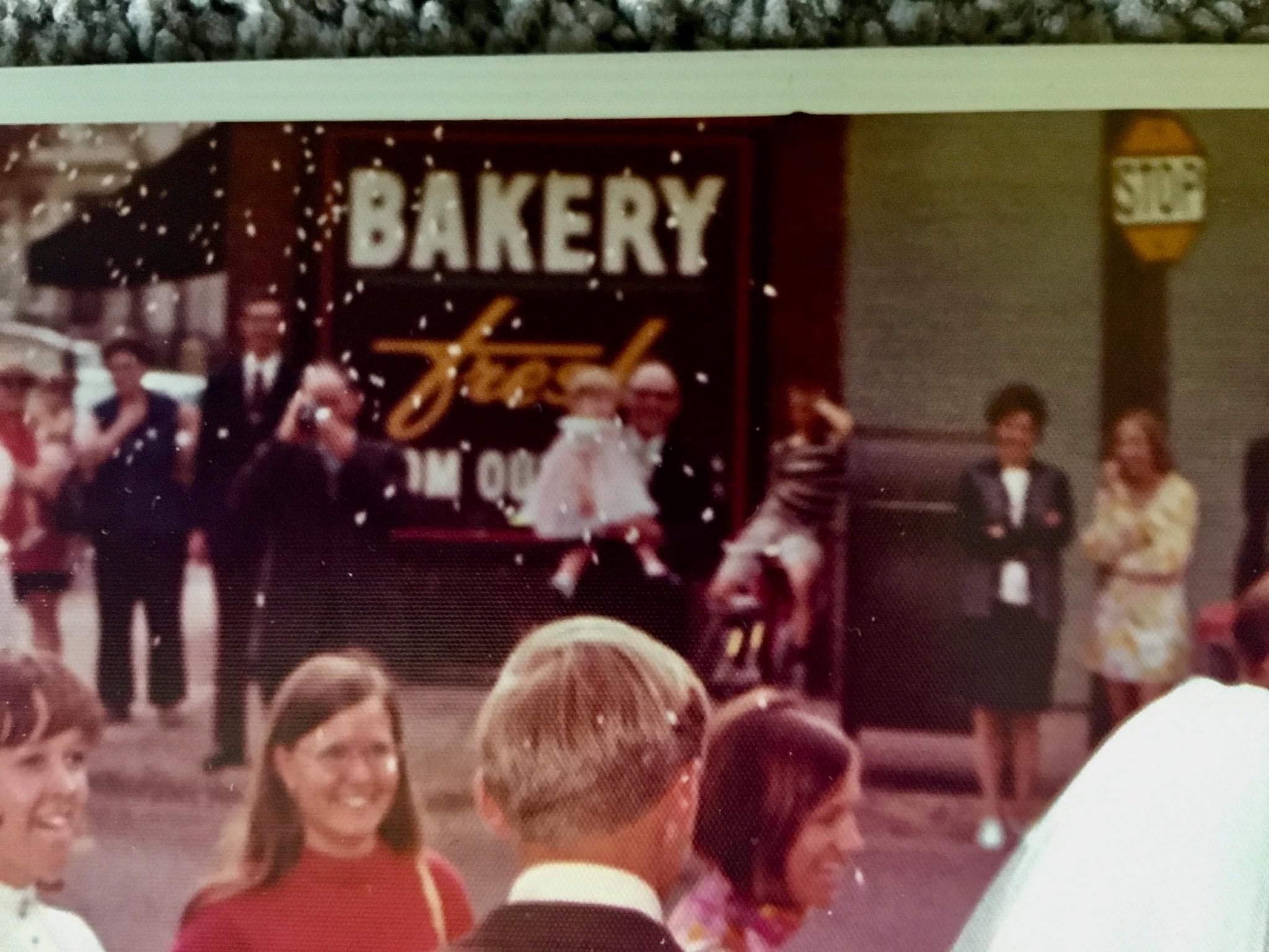 Group of people in front of bakery sign