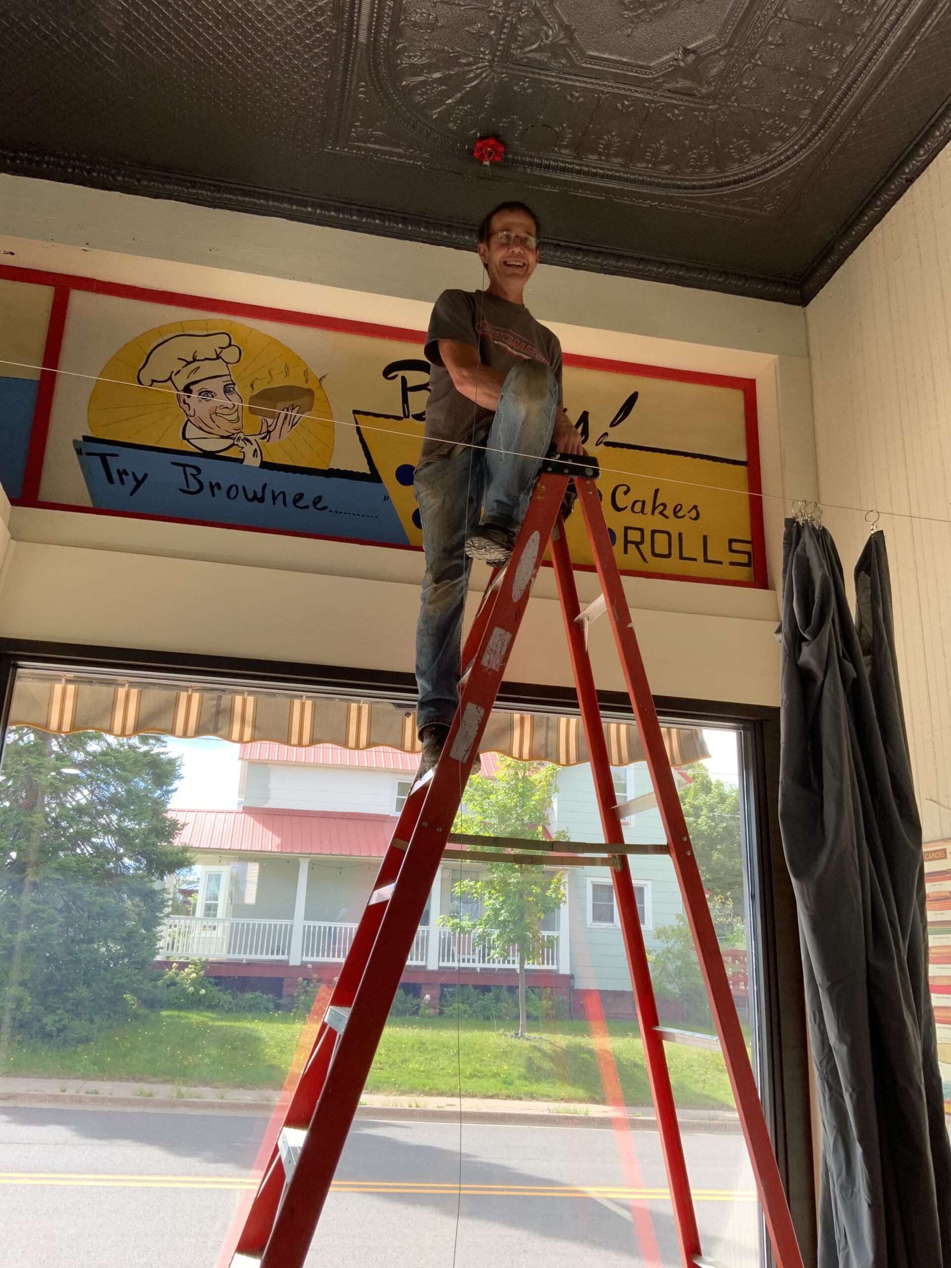 Person on ladder adjusting restaurant sign