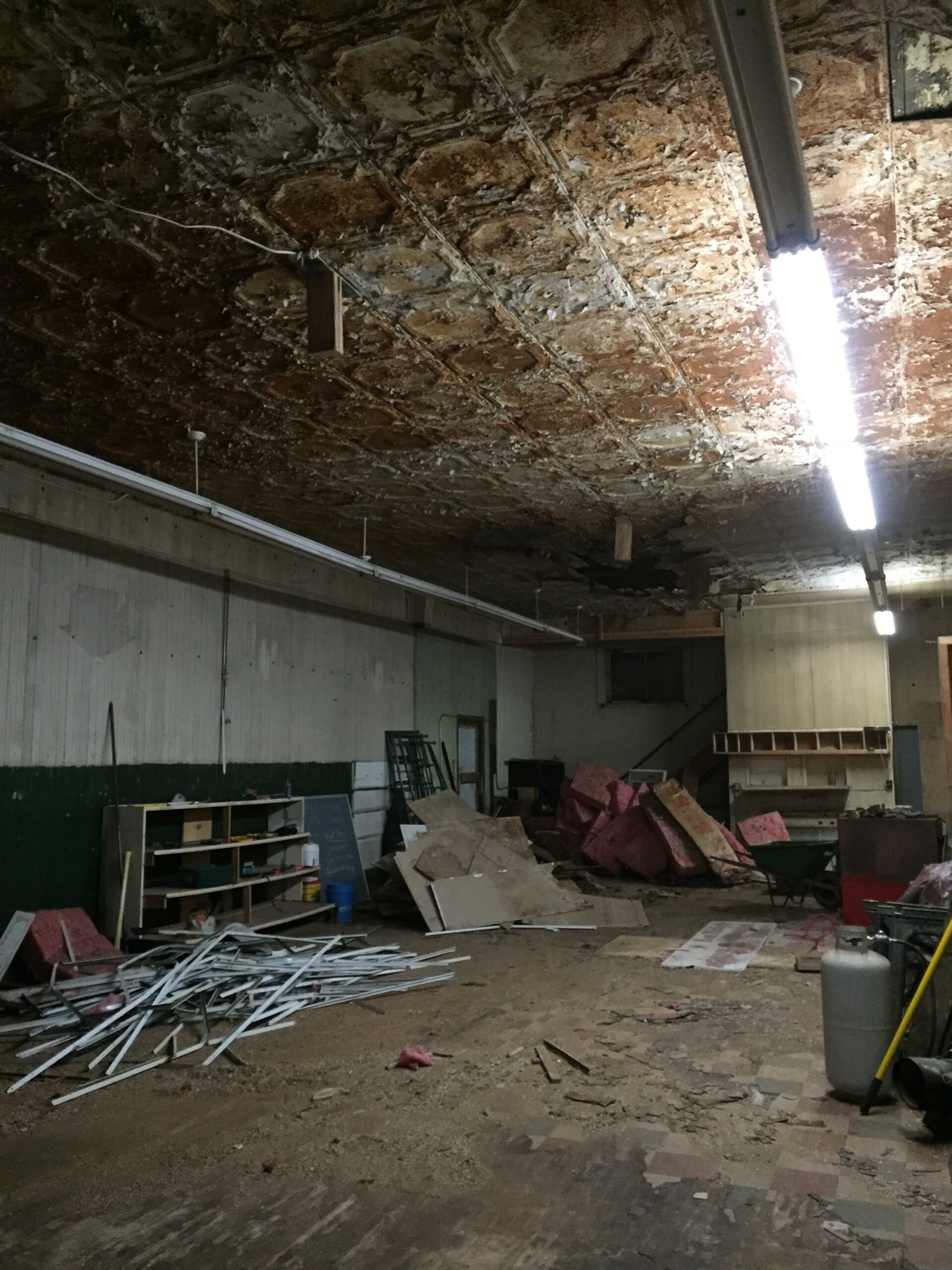 Dimly lit industrial space, peeling ceiling