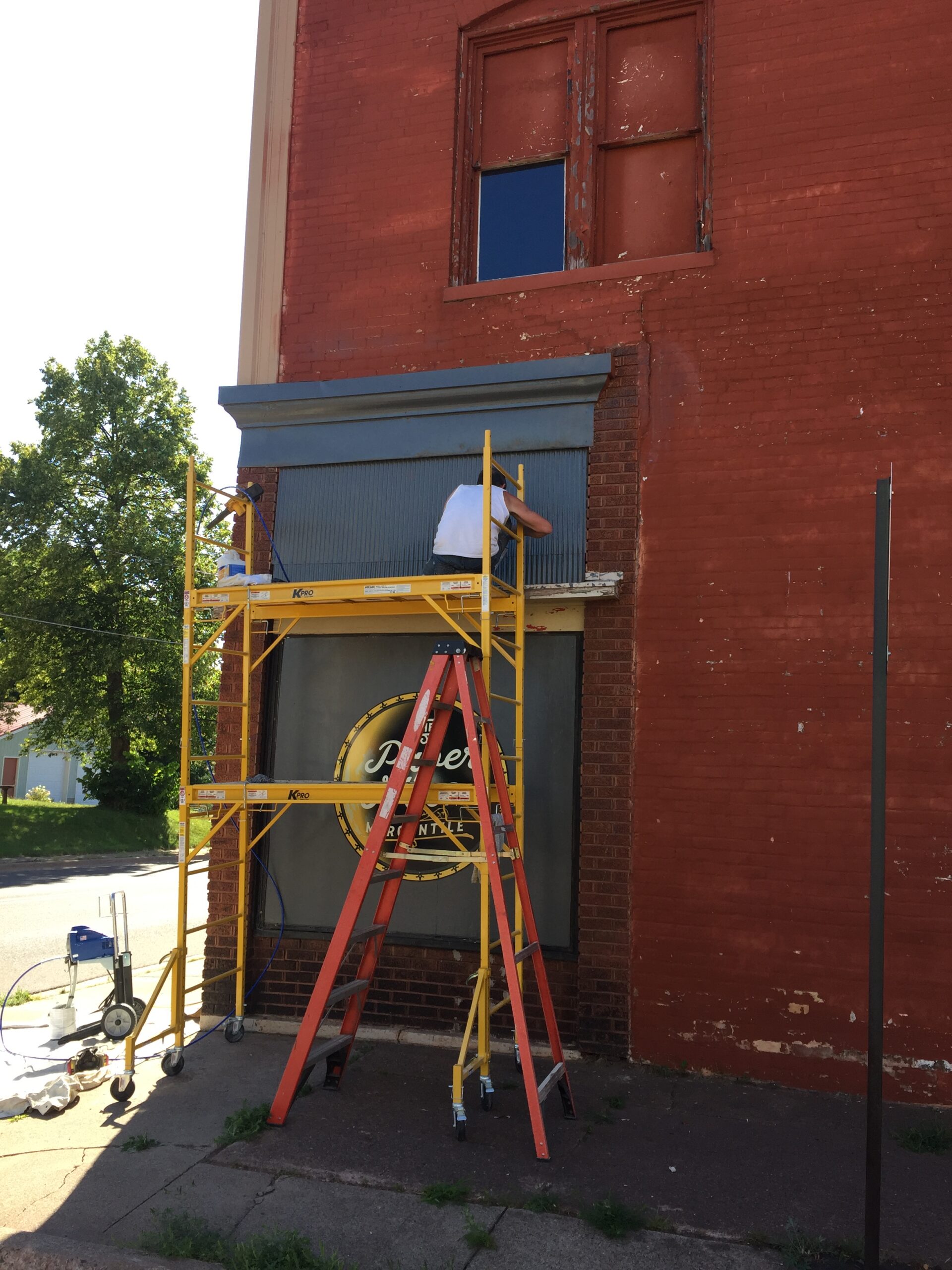Man doing construction work on red building